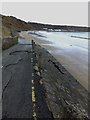 SH3040 : Damaged road surface and sea wall by Richard Hoare