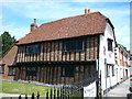 Historical timber clad building next to churchyard