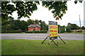 Brick cottages and an advertising board, old road through Laceby