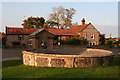 Raised pond with water trough behind it, opposite Upper Sheringham Church