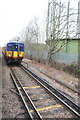 Train passing Motspur Park gas holder on way to Guildford