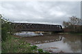 Rail bridge crosses swollen Mersey river at Bridgefoot, Warrington