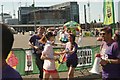 View of a Colour Runner taking a bottle of water at the finish line