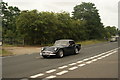 View of a Daimler SP250 passing along London Road as part of the London-Southend Classic Car Run