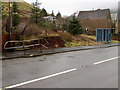 Bus shelter and distorted rusty railings alongside the A4107 in Abergwynfi