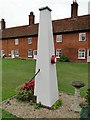 Boxed-in village pump at Boyton Almshouses with firebell