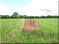 Path across field with pole and abandoned bucket from digger