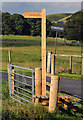 A signpost and stile by the A708 at Kirkstead