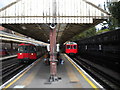 Two westbound trains arriving at Barons Court station