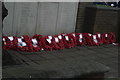 View of a line of poppy wreaths in front of the war memorial in Billericay