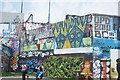 View of street art on the wall of a warehouse on the Hertford Union Canal towpath reflected in the canal #3