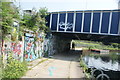 View of street art under the old railway bridge from the River Lea towpath