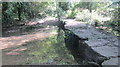 Ancient bridge constructed of large limestone slabs over the Broadmead Brook