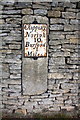 Milestone embedded in wall beside A361