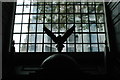 View of a small eagle statue above a display silhouetted against the window in St. Clement Danes Church