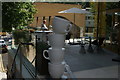 View of giant teacups outside a new cafe at the base of the Hotel Novotel Canary Wharf from Marsh Wall