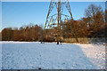 Pylon in snowy open space, Furnace Green, Crawley