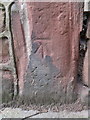 Weathered bench mark in front of Newton Mews, Newton Lane