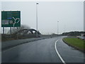 A56 Chester Road crossing the M56, with railway arch bridge beyond