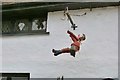 Flowerpot man on a swing in the picturesque village of Berrynarbor, Devon