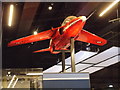 View of a Red Arrow suspended from the ceiling in the RAF Museum