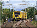 A yellow machine passing through Troon railway station