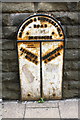 Metal milepost set in Huddersfield Road wall