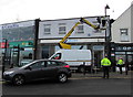 Removing a Christmas decoration from the lamppost outside Barclays Bank, Caerphilly