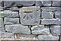 Benchmark on stone in wall on SE side of Holmes Road