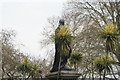 TQ3080 : View of the statue of John Henry Frere hiding behind palm trees in Whitehall Gardens by Robert Lamb