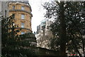 TQ3080 : View of the Playhouse Theatre through the trees from Whitehall Gardens by Robert Lamb