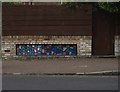 View of mosaic street art on the brick wall in front of the terraced houses on Maple Road