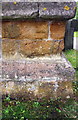 Weathered benchmark on buttress of All Saints Church