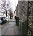 Dark green cabinets alongside a high stone wall, Watton, Brecon