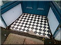 SH6266 : A damaged tiled shop doorway on the High Street, Bethesda by Meirion