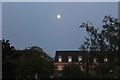 Moon over houses at sunset