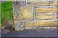 Benchmark on corner of wall at Westgate / Sedgwick Close