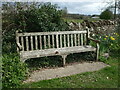 Memorial bench and flowers near Nettleton