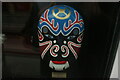 TQ3282 : View of a painted mask in the window of The Old Street Chinese Restaurant #3 by Robert Lamb