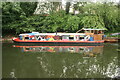 View of a brightly decorated narrowboat reflected in the Regent