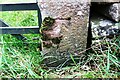 Benchmark on gatepost on NE side of B6412 at Banty Hill