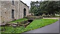 Curved Stone Bridge over stream by Thorpe village green