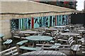 View of art on the wall of the steps leading up to Anchor Street across a sea of tables from the Aurora restaurant