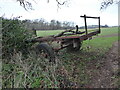 Old abandoned trailer at a gateway into a field