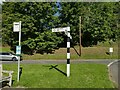 Signpost and bus stop in Hook Norton