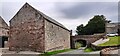 Barn on east side of road and footbridge over the road at Catterlen Hall