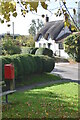 Thatched cottage and post box at Easton Cross Roads