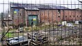 Development site at Greenholme Steading seen through security fence on SE side of A69