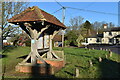 Roofed village notice board by the green at Bentworth