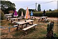 Furled umbrellas and outdoor tables in garden at the Royal Oak Inn, Pett